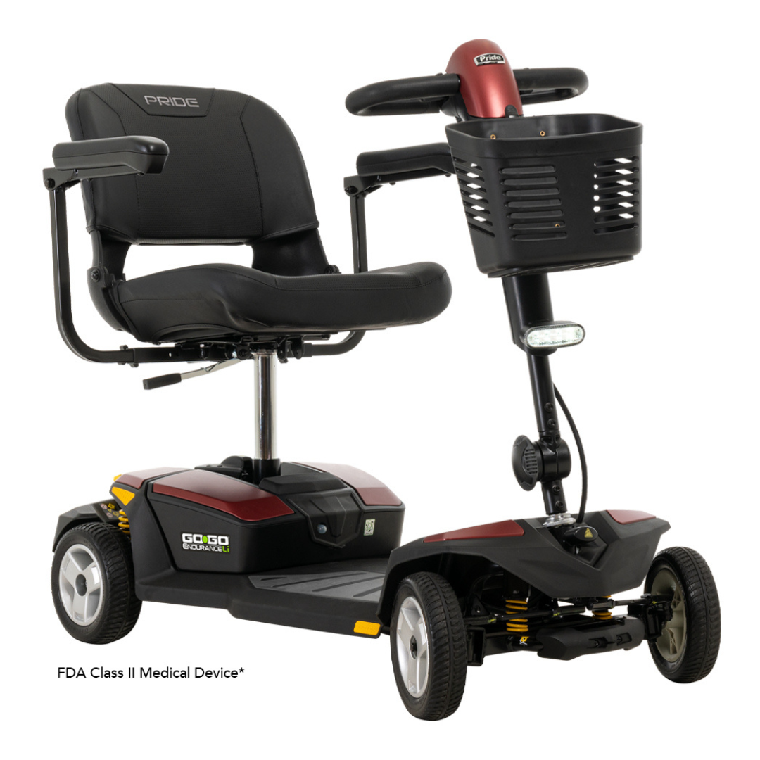 The Pride Mobility Go Go® Endurance Li 4-Wheel Scooter features a red base, black seat, Comfort-Trac Suspension, and advanced lithium battery tech for easy mobility with a handlebar-basket combo.
